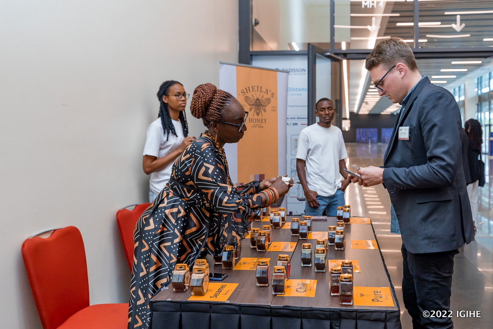 A participant of the summit showcasing honey products to guests. 
