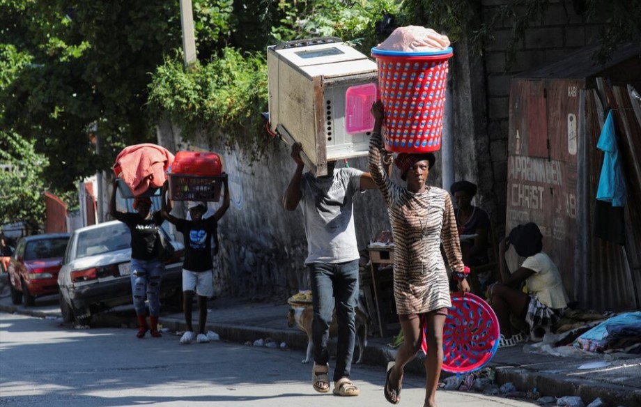 People carrying their belongings flee their homes from gang violence in Port-au-Prince, Haiti on October 26, 2024.
