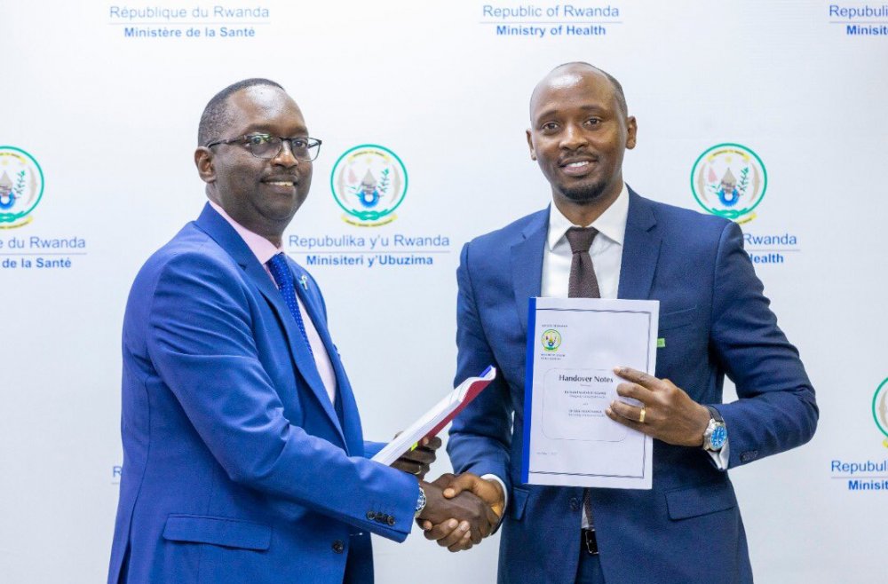 Dr. Ngamije (left) presenting a handover note to his successor, Dr. Nsanzimana.  