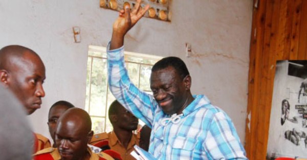 Besigye flashes the FDC symbol at the Kasangati Magistrate’s Court in Wakiso District yesterday.