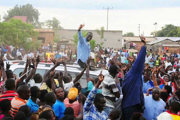 Welcomed. Former FDC leader Kizza Besigye waves to residents of Bbaale in Kayunga District during his ongoing anti-land grabbing campaign yesterday.