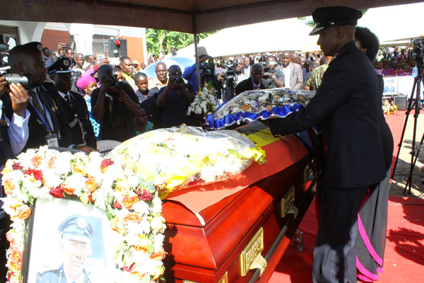Rest in Peace. IGP Kale Kayihura lays a wreath on the casket containing the remains of AIGP Andrew Felix Kaweesi during the burial ceremony at the deceased’s country home in Kitwekyanjovu village in Lwengo District.