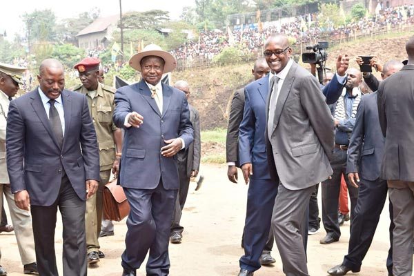 President Museveni (centre) ushers in DRC President Joseph Kabila (left), as Lt Gen Henry Tumukunde (right) looks on at the Congo border in Kasese District on Thursday ahead of their bilateral talks at the Mweya Safari Lodge.