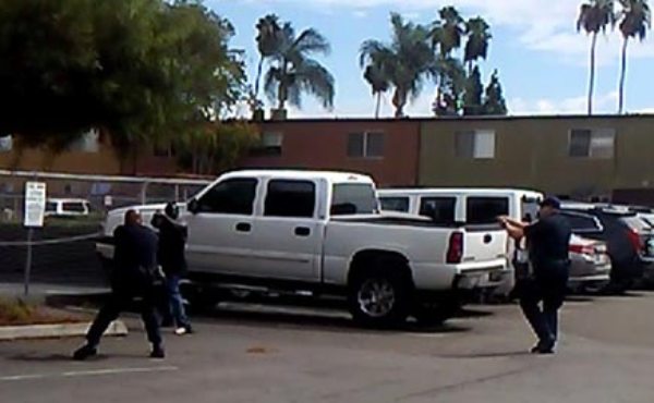 In this video grab courtesy of the El Cajon Police Department and obtained by AFP on September 28, 2016, a man said to be Alfred Olango raises his hands as members of the police department approach in El Cajon a suburb of San Diego, California.