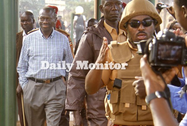 Former Forum for Democratic Change presidential candidate Kizza Besigye (left) is led by warders to the court cells after he was charged with treason at Nakawa Magistrate’s Court in Kampala yesterday.
