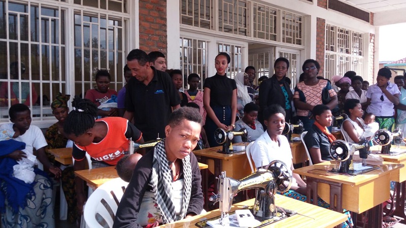 Miss Sharifa looks on as beneficiaries on sewing machines test them