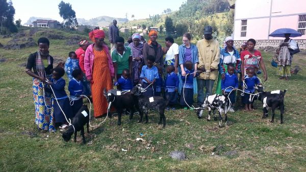 Beneficiaries of Own goat project holding donations as they pose for a photo with Ann Mcminn