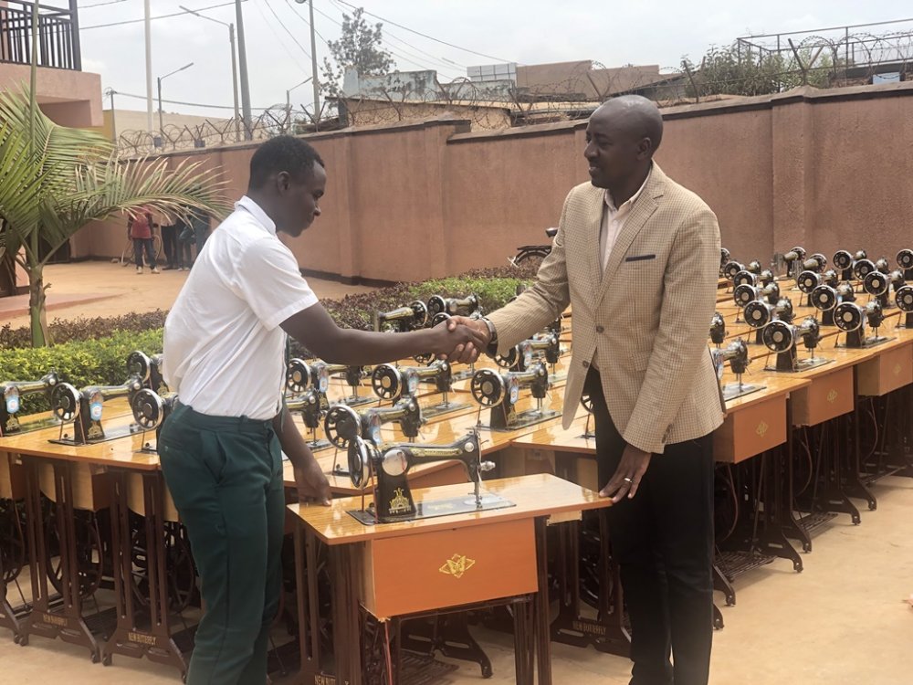 The Mayor of Rwamagana District, Mbonyumuvunyi handing over a sewing machine to one of graduates. 
