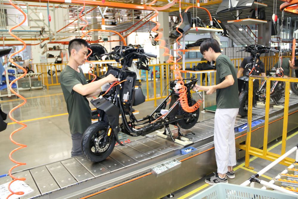 Chinese assemble an electric scooter at the headquarters of Yadea in Chongqing Municipal Province in China. Photo by Théophile Niyitegeka