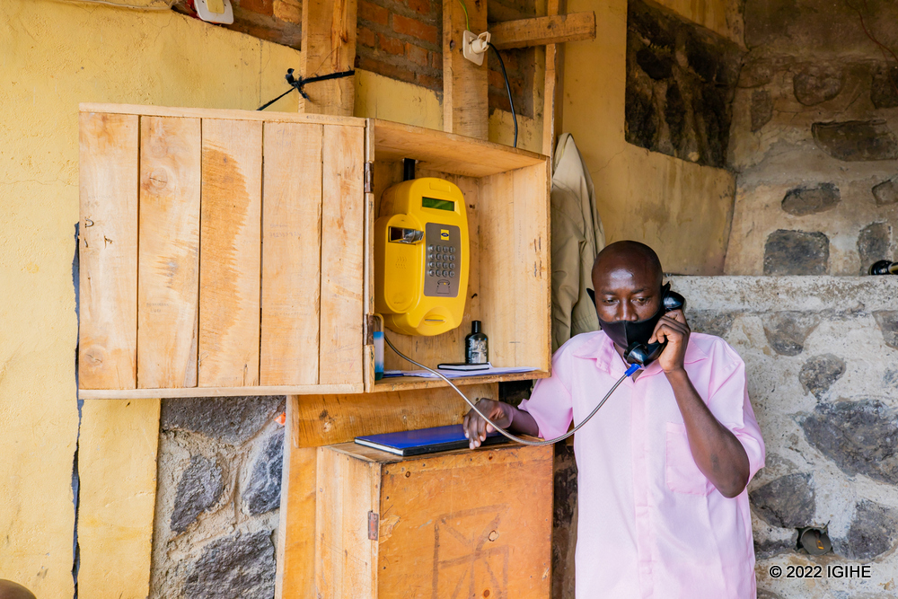 An inmate speaking to relatives using a public phone.