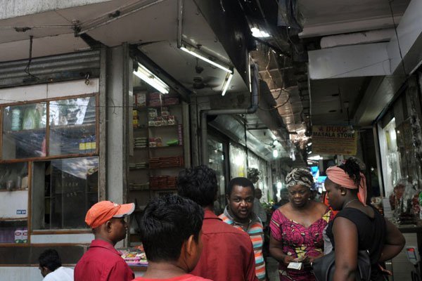 In this photograph taken on July 14, 2015, African customers (right) speak with Indian traders at a market in New Delhi. Around 30,000 Africans live in New Delhi, according to police, and they have told AFP of numerous humiliations they face, from insults in the street to housing discrimination and even violent attacks.