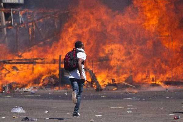 Zimbabwe's opposition supporters set up a burning barricade as they clash with police during a protest for electoral reforms on August 26, 2016 in Harare, Zimbabwe.