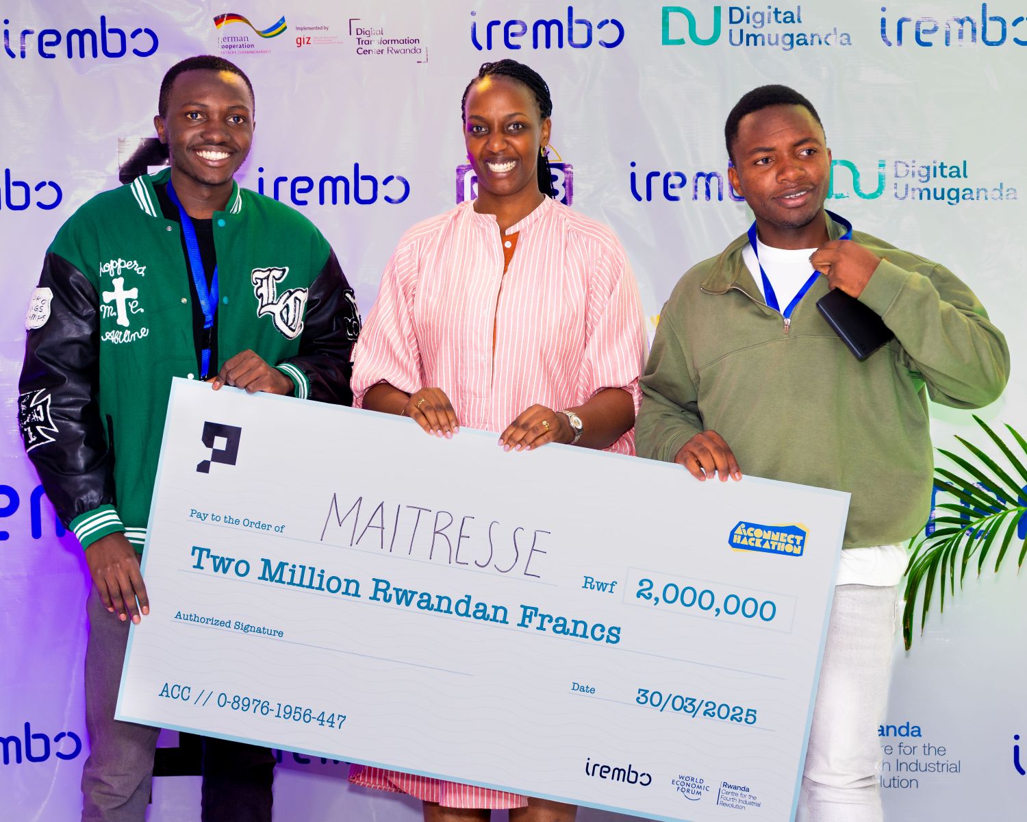 "A representative from Proto hands Libériste Clarence (left) and his teammate, Ndizihiwe Regis (right), a RWF 2 million dummy cheque.
