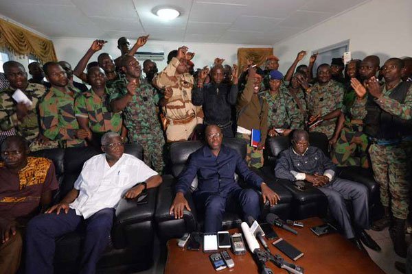 A delegation of mutinous soldiers stand behind Ivory Coast's defence minister Alain-Richard Donwahi (Centre) speaking to journalists after negotiations, on January 7, 2017 in Bouake.
