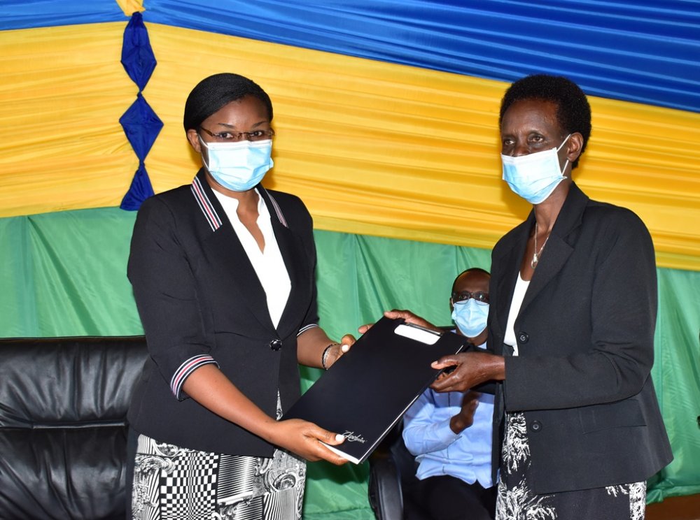 Valérie Mukabayire, the President of Avega Agahozo (an organisation that brings together widows of the Genocide against the Tutsi) handing the notarized will to the Minister in the Office of the President, Judith Uwizeye.