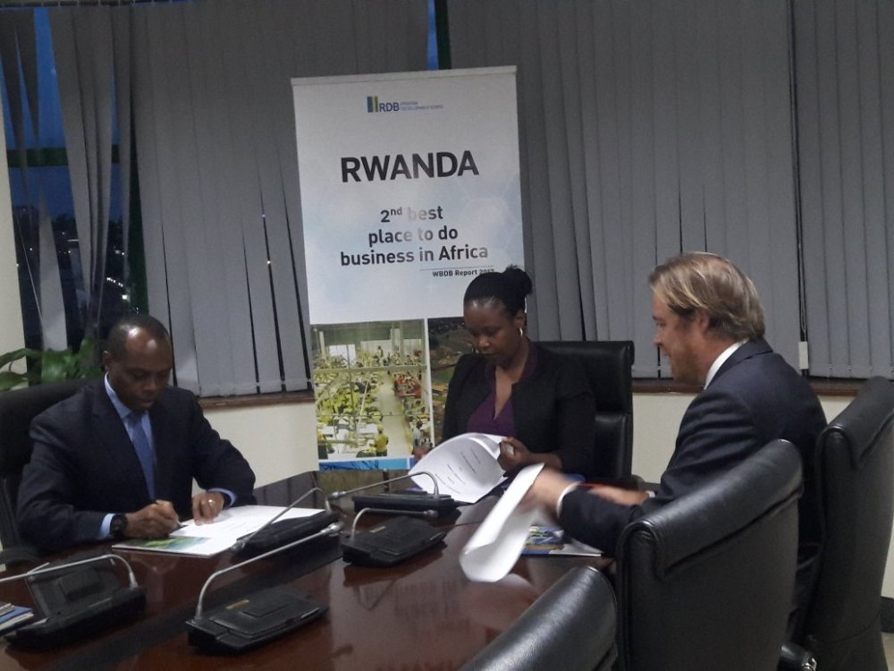 The Rwanda Mines, Petroleum and Gas Board, CEO, Francis Gatare and the Rwanda Development Board (RDB)' CEO, Clare Akamanzi signing a memorandum of understanding with The CEO of PRG Plc, Ray Power