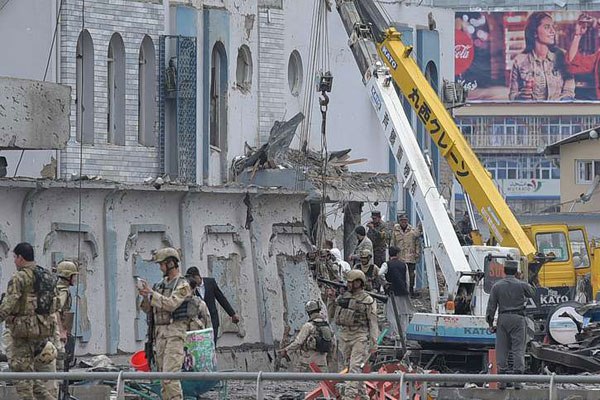 Afghan security personnel inspect the site of a car bomb attack at the gate of a government office in the Puli Mahmood Khan neighbourhood of Kabul on April 19, 2016. A powerful Taliban car bomb followed by a fierce firefight left 30 people dead and hundred wounded.