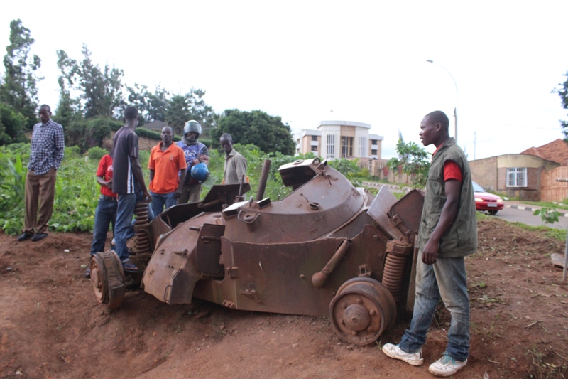 Residents watching wreckage of an armored vehicle on caterpillar that was blown by RPA liberators at Kagugu hill.