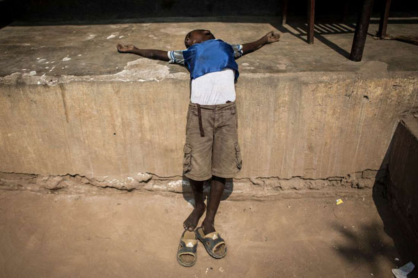 A Congolese boy rests on a wall as he waits for food at a camp for internally displaced persons (IDPs) fleeing from the conflict in Kasai on June 4, 2017 in Kikwit. Thousands have died while more than 1.3 million people have fled the fighting. AFP PHOTO