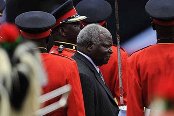 Former President Mwai Kibaki inspecting a guard of honour. Mr Kibaki will spend at least one more week at a South African hospital, a source privy to the former president’s health status said.