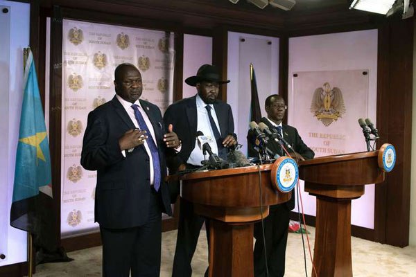 First Vice President Riek Machar (left) delivers a speech to journalists next to South Sudan President Salva Kiir (centre) and Vice President James Wani Igga (right) prior to the shooting outside the presidential palace in Juba on July 8, 2016.