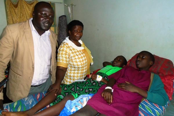 Kayunga RDC Rose Birungi and her deputy Yahaya Were visit some of the pupils who were admitted to Kangulumira Health Centre IV after eating food suspected to have been laced with poison.