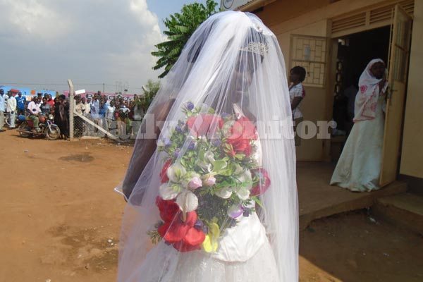 The bride who's said to be underage in her gown at Iganga police station.
