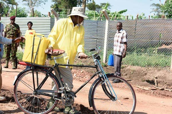 President Museveni carrying a jerrycan of water on a bicycle at his new farm in Luweero District recently.