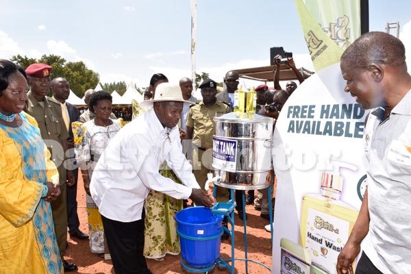President Yoweri Museveni washes his hands with soap during the Global Hand Washing day at Kamuli Boma Grounds on October 14, 2016 as Speaker Rebecca Kadaga (L) looks on.