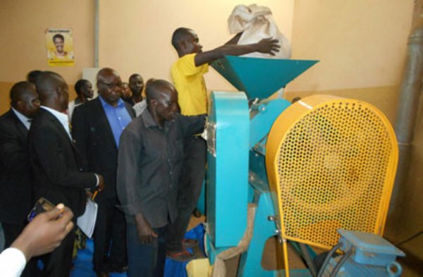 Mpigi RDC Hajji Swaibu Lubega Wagwa (blue shirt) inspects a new coffee processing plant set up at Kamengo Trading Center.