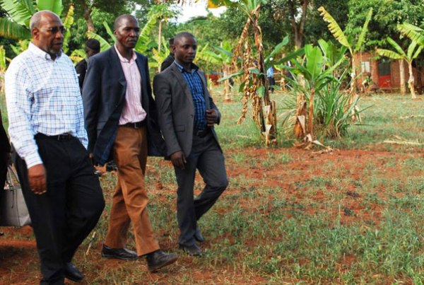Dr Ruganda (L), and Kalungu District officials inspect one of the gardens where crops have failed due to prolonged drought.