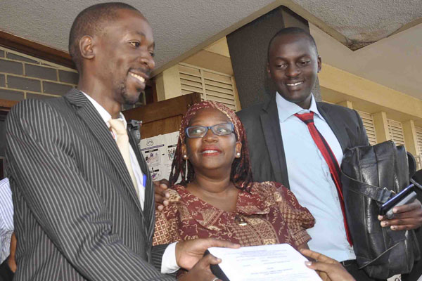 Dr Stella Nyanzi (M) with by her lawyers Isaac Semakade (L) and Emma Kiiza at Buganda Road court after court rejected the State's plea to have her subjected to a mental test.