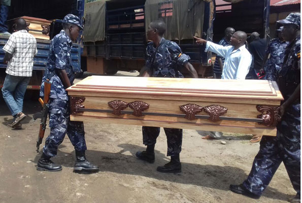 A file photo of police officers carrying a casket containing a body of their colleague who died in the Kasese violence.