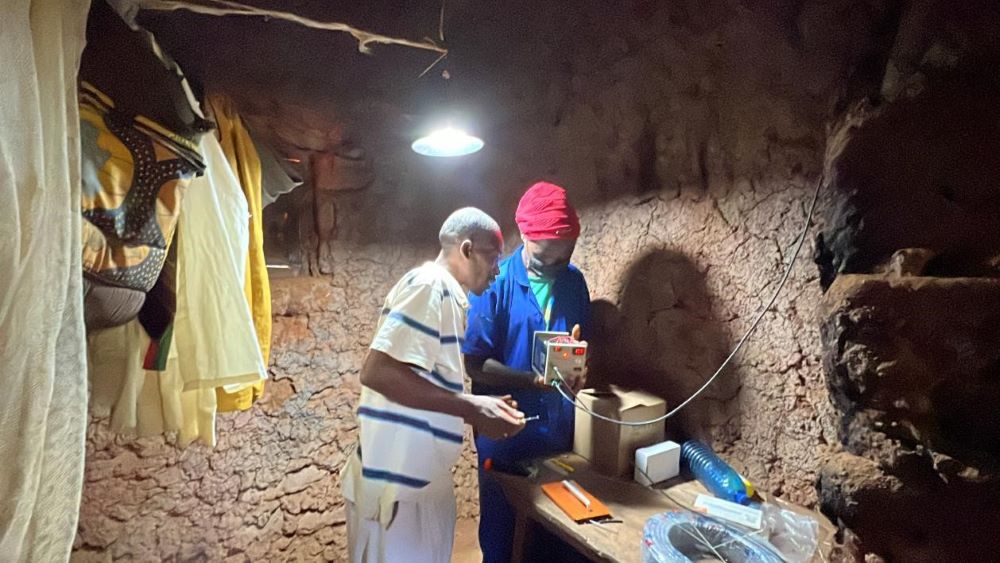 A local student shows the owner of the house how to use the solar system. (Photo by Su Ting)