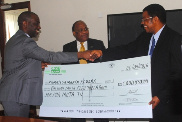 The Prime Minister, Mr Kassim Majaliwa, receives a dummy cheque for 1 billion/- from the Treasury Registrar, Mr Lawrence Mafuru (left) and the Chief Secretary, Ambassador John Kijazi, in support of the earthquake victims in Kagera Region. The funds have been contributed by public servants and their institutions. The occasion was held in Dar es Salaam yesterday.