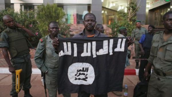 Malian security officials show a jihadist flag they said belonged to the attackers.
