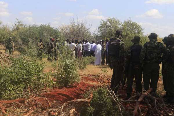 Police officers at one of the mass graves yesterday at Lathe Village in Mandera County. Twelve bodies were exhumed