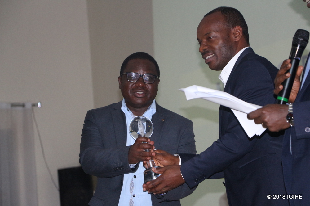 Nyaruguru District Mayor François Habitegeko (R) receives the award