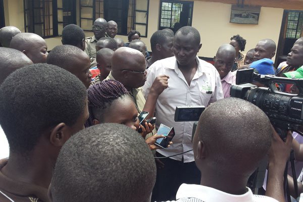 Protesting Migori town residents storm the regional police headquarters demanding to know from county Commander David Kirui (in glasses) why a Form Two student from Ulanda Girls High School was shot and critically injured by prison warders pursuing an escaped inmate.