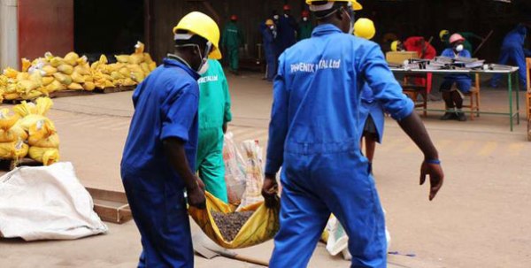 Workers carry minerals for weight registration before the smelting process. Rwanda’s mining sector is picking up.