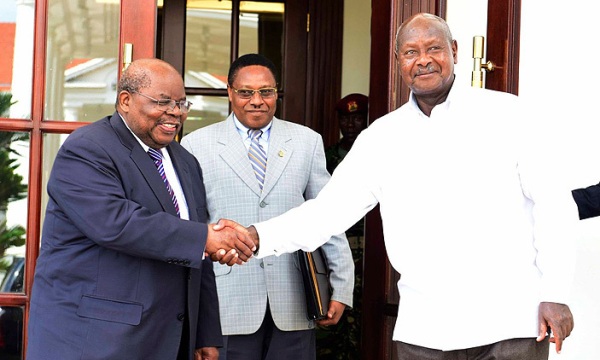 President Yoweri Museveni shakes hand with former Tanzanian president Benjamin Mkapa.