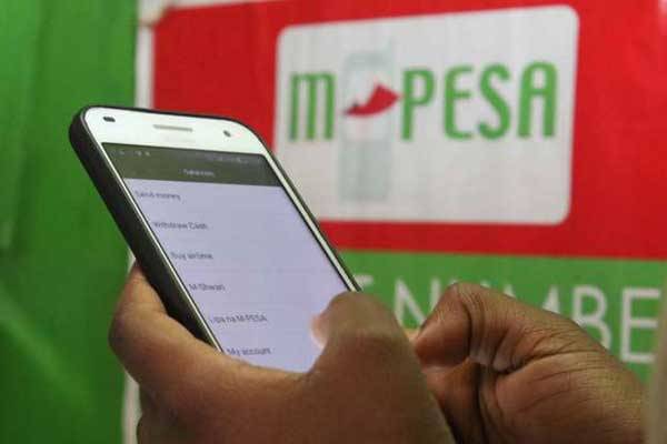 A mobile subscriber withdraws money from an M-Pesa shop in Nyeri on May 2, 2016. Across Africa more and more people are now spending, saving and planning for the future through banking services offered by mobile phone companies.