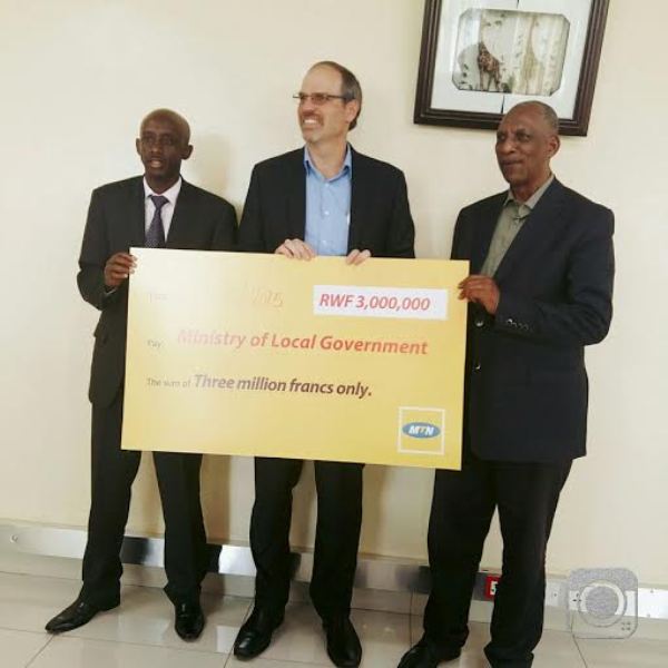 MTN CEO, Gunter Engling (M) hands over  the cheque to Hon. Francis Kaboneka