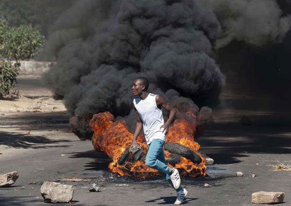 A protester throws rocks during a demonstration in Bulawayo, Zimbabwe, on July 6, 2016. Zanu PF has already endorsed President Mugabe to stand for yet another term in the 2018 elections.