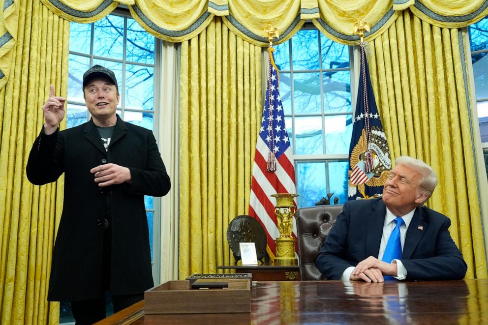 President Donald Trump listens as Elon Musk speaks in the Oval Office at the White House.