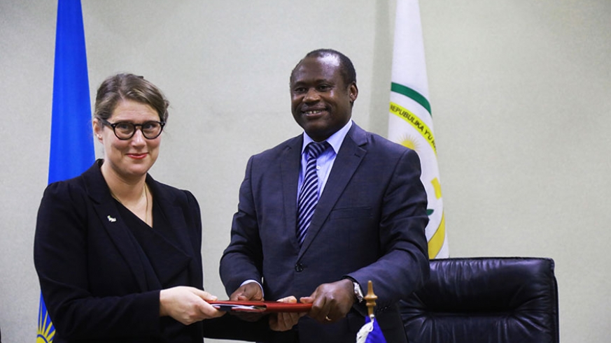 The Minister for Finance and Economic planning Uzziel Ndagijimana (right) and Amb. Jenny Ohlsson, the Swedish envoy to Rwanda, exchange documents after signing the agreement in Kigali yesterday.
