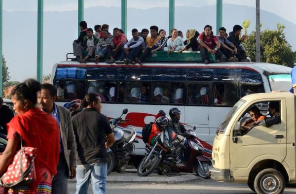 A bus accident in Nepal killed 30 people Monday. In this photo, dated Oct. 15, 2015, Nepalese commuters travel atop a public bus