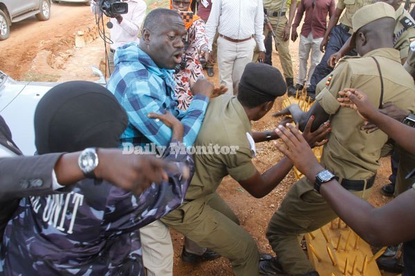 Dr Besigye scuffling with police officers at his home in Kasangati.