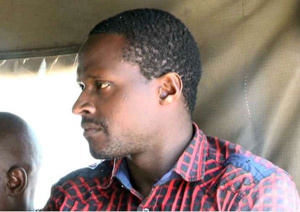 Mr Stephen Ngila Nthenge, who is suspected of chopping off his wife's hands at Kathama village in Machakos County, sits in a police vehicle after being charged with attempted murder at Wamunyu Law Courts on August 1, 2016.