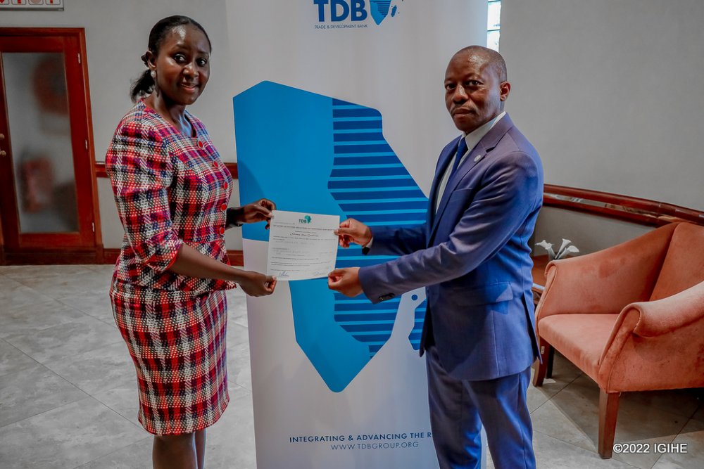 Nyatanyi receiving a certificate given to shareholders of TDB. 